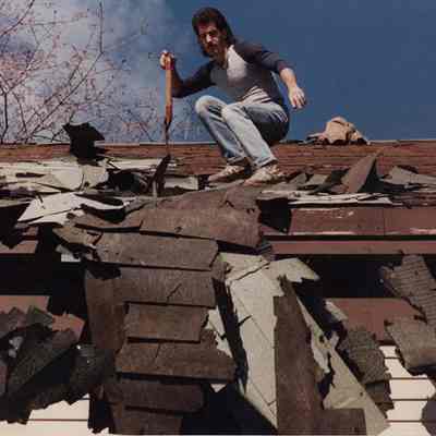 A photo view of a man working on a roof. 6/02/1989.