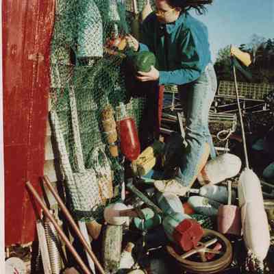 A photo view of a girl hanging a lobster buoy. 12/5/1986.