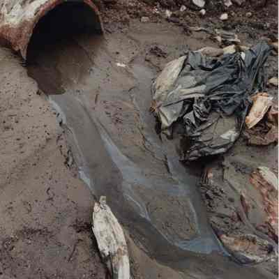 A photo view of a messy drainage pipe. 6/9/1989.