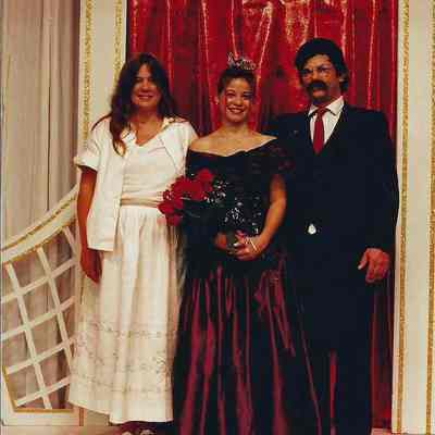 A color photograph of a winning queen and her parents.