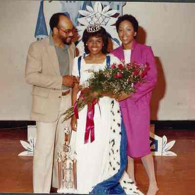 A color photograph of the 1983 Brunswick Teen Queen Kim Carslick with her parents.