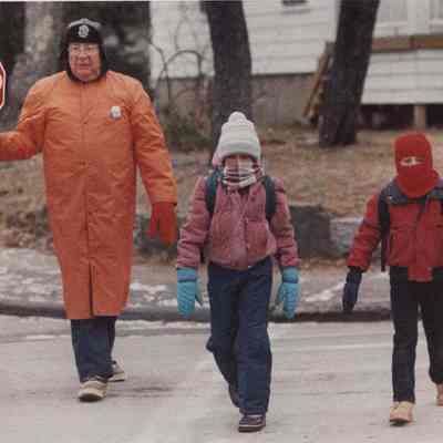 A photo view of a crossing guard and 2 children. 12/11/1986