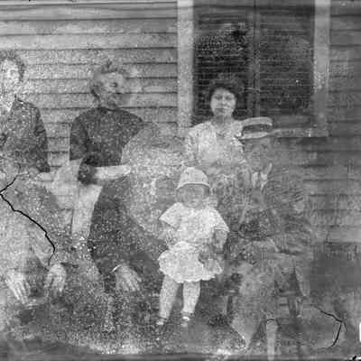 A group of people sitting near a house.