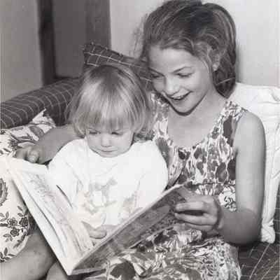 A photo view of two children reading a book. 6/8/1992.