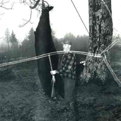A photo of Clarence Skolfield and a bear he shot. 11/20/1954.