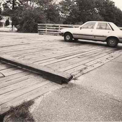 A photo view of a car passing over the railroad tracks.