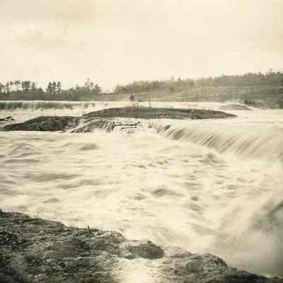 A photo view of a mill on a river.