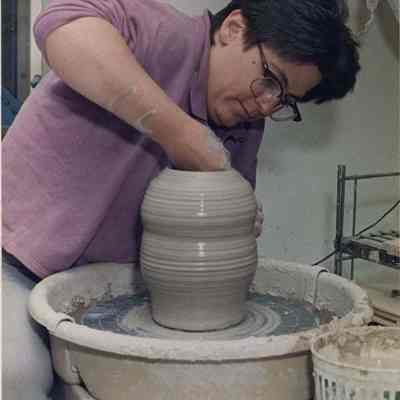 A photo view of a woman at work on a potters wheel. 7/5/1988.
