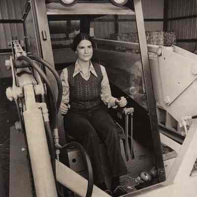 A photo view of a woman driving a front end loader. 5/29/1980.