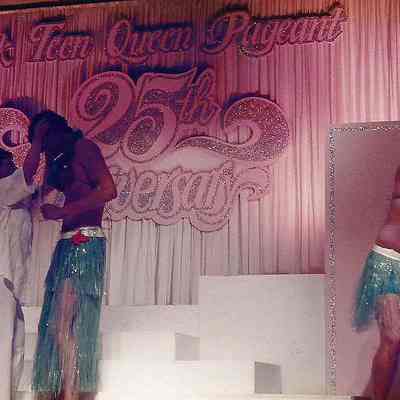 A color photograph of Sharon while dancing is teasing one of the dancers.