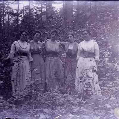 Five women standing in the woods.
