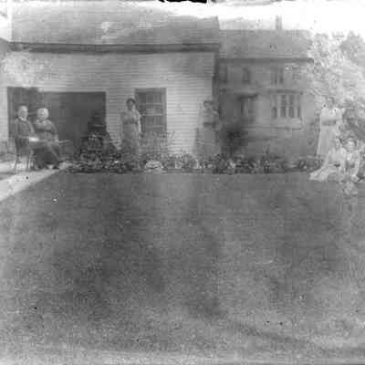A group of people in front of a house.