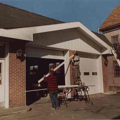 A photo view of workmen putting the finishing touches to a garage. 3/23/1988.