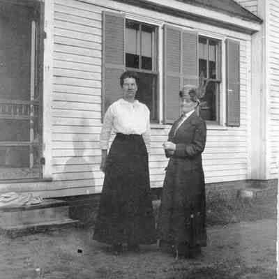 Two Women Standing in Front of a Building