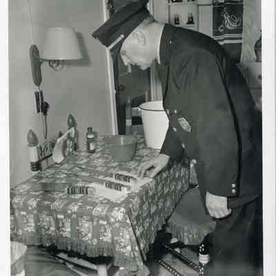 Policeman looking at knives used in a murder