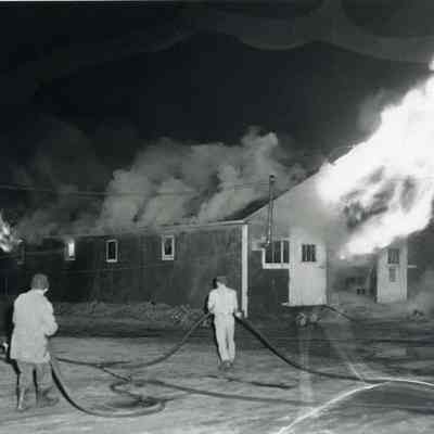 A photo of one of the animal sheds burning.