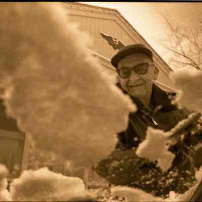 A photo view of someone scraping their windshield. 12/4/1984.