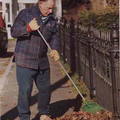 A photo view of a man raking leaves. 4/14/1988.