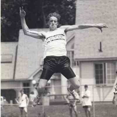 A photo view of a man doing the broad jump.
