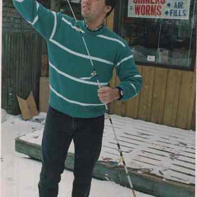 A photo view of a man and his fishing rod. 3/18/1987.