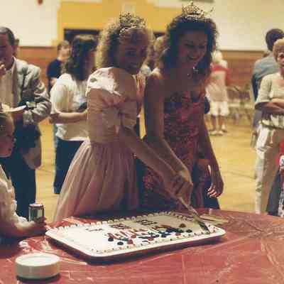 the winners Robin Moody and Stacy Bean cutting the cake.