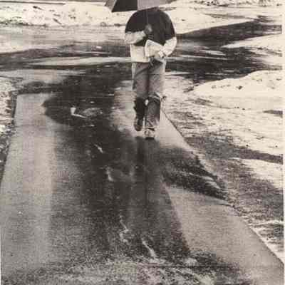 A photo view of a Bowdoin Student walking in the rain. 1/15/1992.