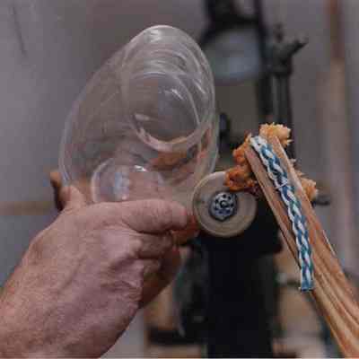 A photo view of a man polishing a piece of glass. 3/27/1992.