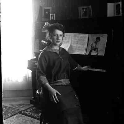 A view of a woman sitting at a piano.