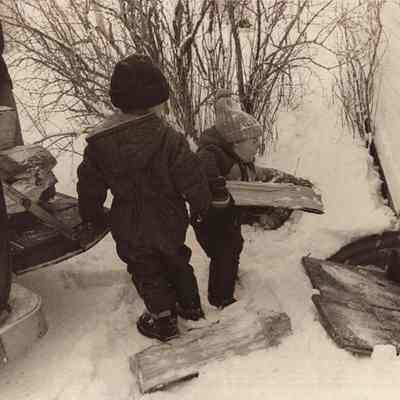 A photo view of Christopher Livesay family putting wood into the house.