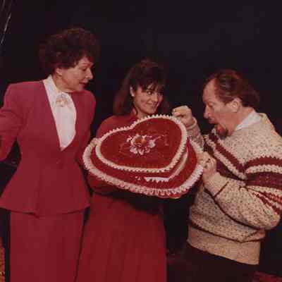 A photo view of 3 people with a valentine shaped hat. 2/12/1988