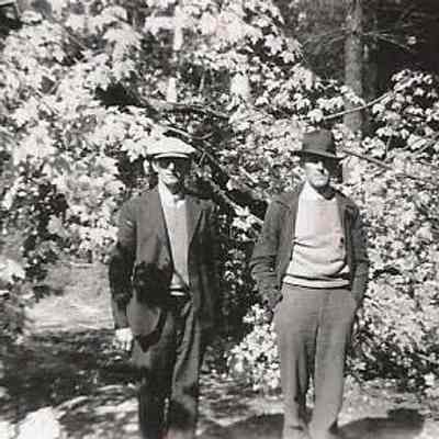 Two Unidentified Men Standing near some Bushes