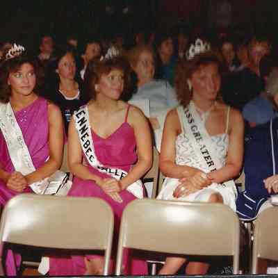 A color photograph of the visiting Queens watching the production.