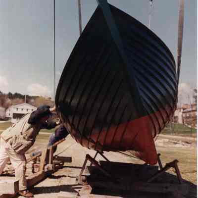 A photo view of a boat being lowered into a cradle. 5/10/1989.
