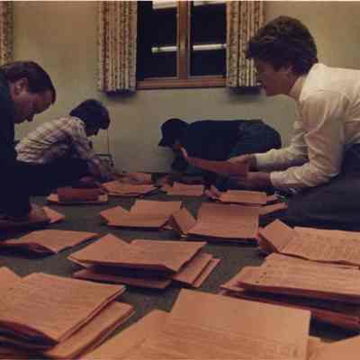 A photo view of people sorting papers. 11/8/1988.