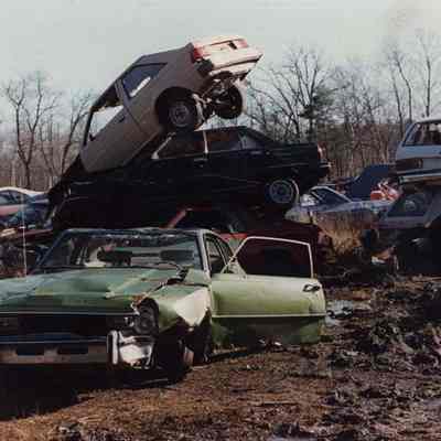 A photo view of a pile of cars in a junk yard. 1/15/1990.