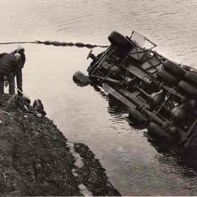 A photo view of Martin Baker Well Drilling truck in the water.