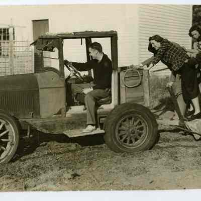 Five (identified) people pushing an old truck