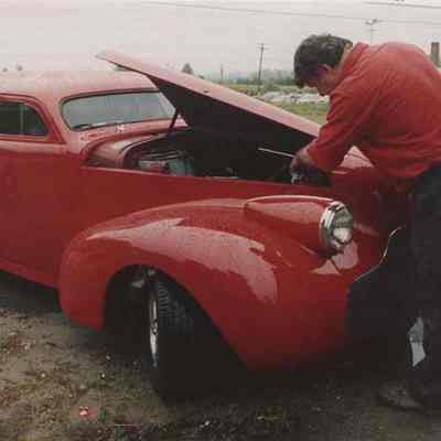 A photo view of a man working on an antique car. 9/10/1987.