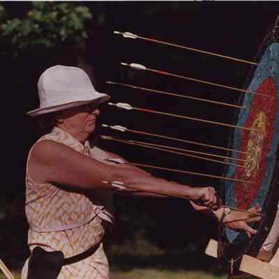 A photo view of a woman archer taking her arrows out of a target. 8/10/1987.