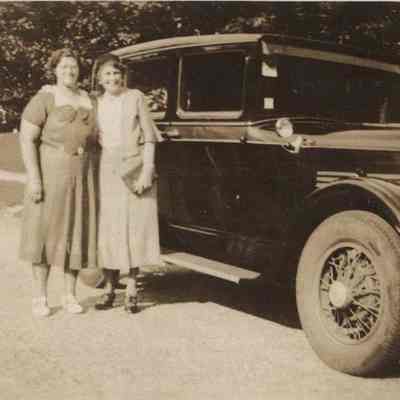 Two Women Standing by a Car