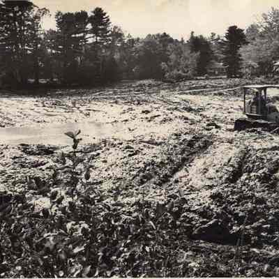 A photo view of Lewis Stuart cleaning his pond. 9/14/1992.