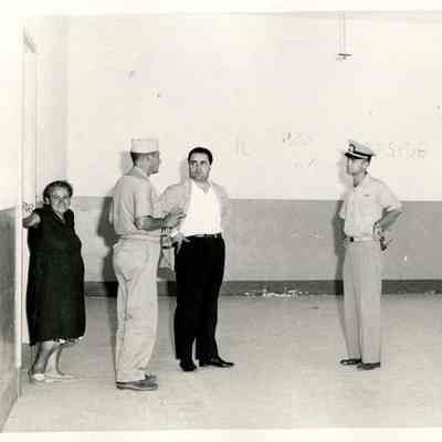 Navy Men in an Empty Room with a Civilian