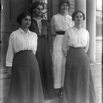 Four women in front of a door.