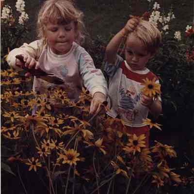 A photo view of two children collecting flowers. 8/22/1988.