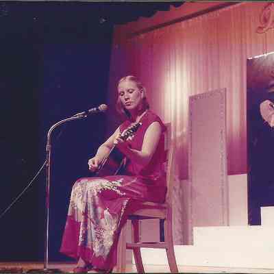 A color photograph of Elizabeth Coffin Lemieux a 1976 contestant playing guitar.
