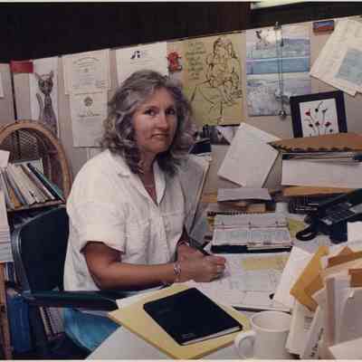 A photo view of a woman working at a desk. 9/5/1991.
