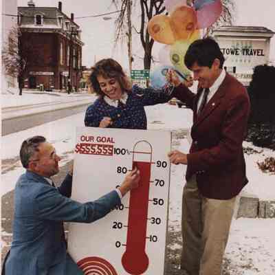 A photo view of 3 people updating the United Way sign. 11/20/1986.