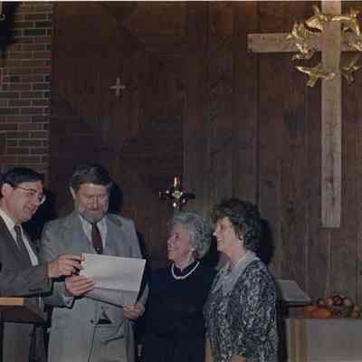 A photo view of 4 people in a church. 11/25/1988.