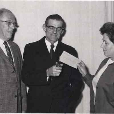 A photo view of three people burning something.