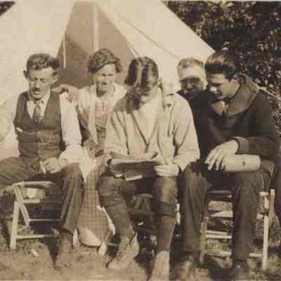 Five People Sitting in Front of a Tent